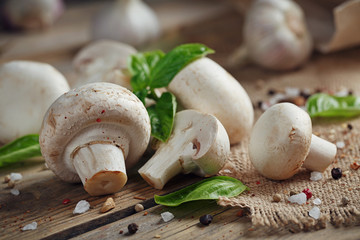 Fresh mushrooms and garlic on wooden background