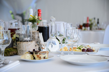 Served table with white tablecloth in the restaurant. Festive table with food and champagne in the Banquet hall. The celebration of luxury. Dinner party.