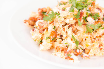 Scrambled eggs with chanterelle and parsley with some white bread on a white background