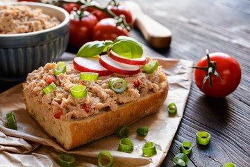 Slices of baguette with tuna spread, red pepper and green onion