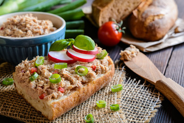 Slices of baguette with tuna spread, red pepper and green onion
