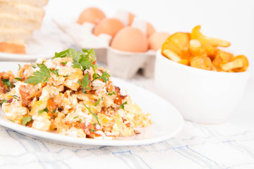 Scrambled eggs with chanterelle and parsley on a white background
