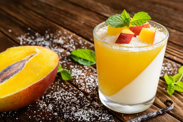 Coconut panna cotta dessert with mango jelly in a glass jar