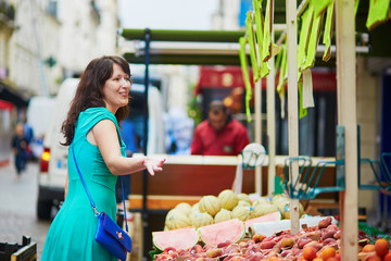 French woman choosing fruits on market