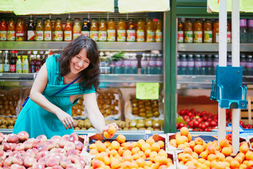 French woman choosing fruits on market