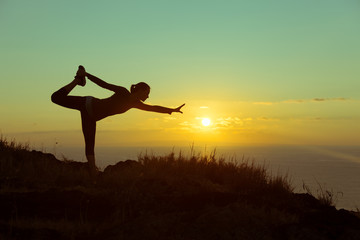 Woman doing Yoga and balance exercise outdoors. 