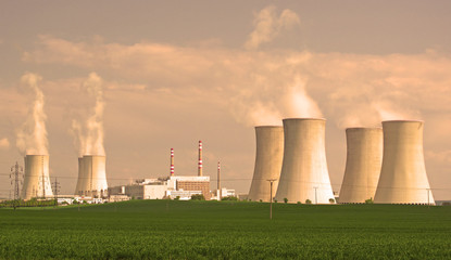 Nuclear power plant. Giant cooling towers with vapor. Nuclear power production concept. Wide panoramic view.