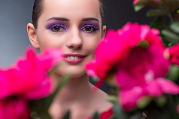 Naklejka premium Young woman with flowers in beauty concept