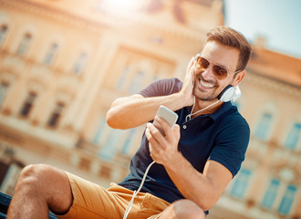 Young man listening to music on a smart phone