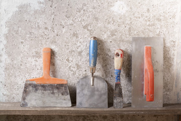 Construction tools on concrete background. Copy space for text. Set of assorted plaster trowel and...