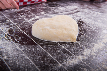 Cook preparing dough for baking in the kitchen