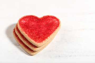 Obraz na płótnie Canvas heart shaped cookies for Valentine's Day arranged and isolated on white board, close up, macro, selective focus, horizontal