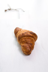 buttered croissant, isolated on white cutting board. close up, vertical