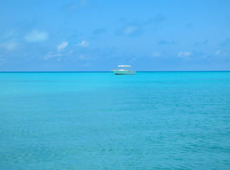 Obraz premium Small yacht anchored in the blue water off the coast of Bermuda