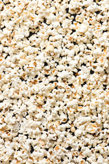 full frame of popcorn as a background, isolated on a black, top view