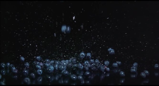 Blueberries falling in slow motion on black background