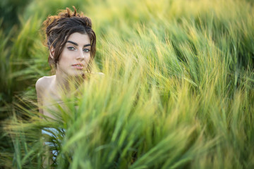 Girl sits in rye field