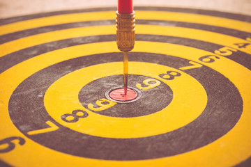 Red dart arrow put on center of dartboard - business concept success target
