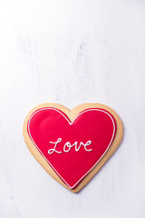 heart shaped Valentine cookie with red and white sugar icing on it, isolated over white background, top view, vertical