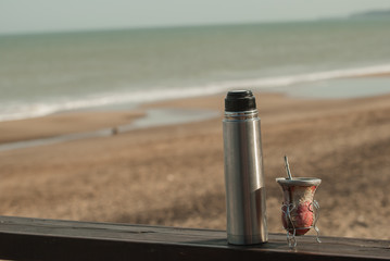 mate y termo en la playa al atardecer © chfortunato2015