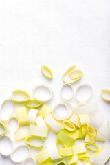 fresh, organic leek cuts, isolated over white, table cloth with lots of copy space area, top view, vertical
