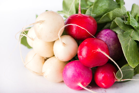 bunch of organically grown, freshly harvested, colorful Easter egg radishes, isolated over white board, close up, horizontal