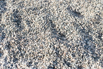 texture of small stones in a construction area. texture of pebbles with truck wheel trace, horizontal, nobody