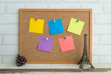 Cork board and colorful paper notes on white background.
