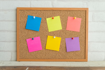 Colorful paper note on cork board with white background.