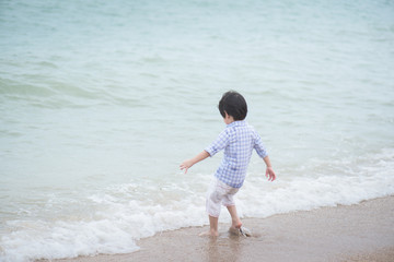Fototapeta na wymiar asian boy playing on the beach