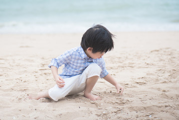 asian boy playing on the beach