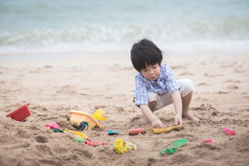 asian boy playing on the beach