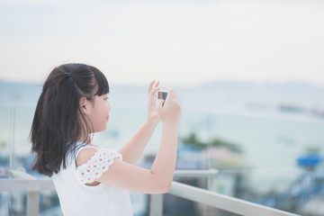 sian girl use smart phone taking photo