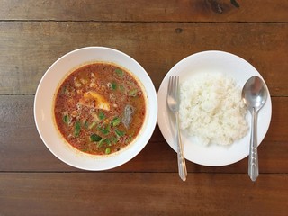 Spicy soup with rice.Hot & spicy soup with pork on wooden table.