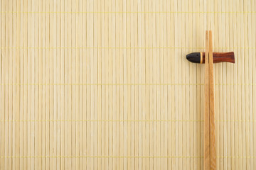 Flat lay handmade sushi chopsticks on Japanese mat background 