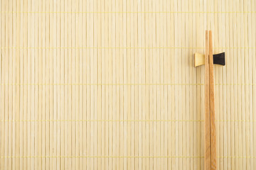 Flat lay handmade sushi chopsticks on Japanese mat background 