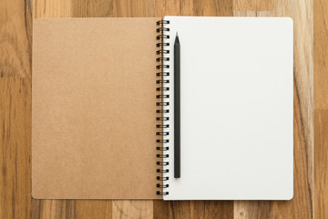 Blank empty notepad and pencil on wooden table background - Business and education concept.
