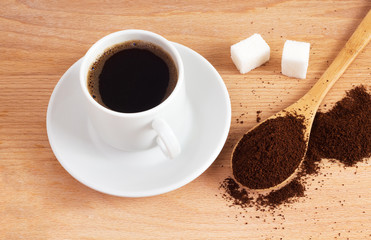Cup of ground coffee in a spoon on the table