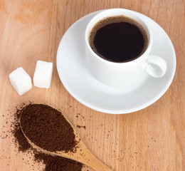 Cup of ground coffee in a spoon on the table