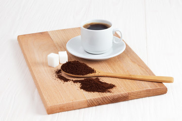 Cup of ground coffee in a spoon on the table