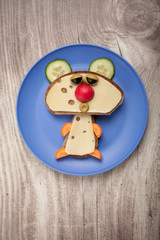 Funny bear made of bread and cheese on plate and desk
