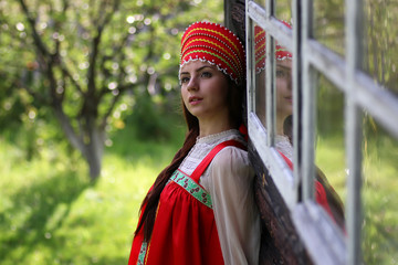 Fototapeta premium Slav woman in traditional dress wooden wall