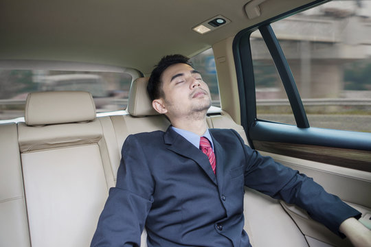 Businessman resting inside a car