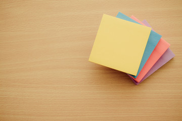Color block of paper notes on wooden table background.