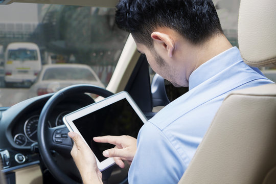 Man uses tablet in the car