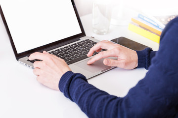 Unrecognizable man using a modern portable computer on an white