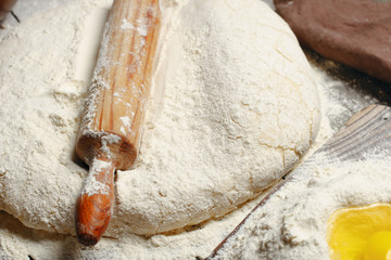 Rolling pin with dough on the wooden table