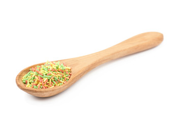 Spoon full of candy sprinkles isolated
