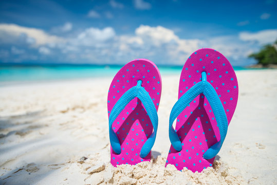 Pink beach flip flop on beautiful tropical island white sand beach summer holiday - Travel summer vacation concept.	