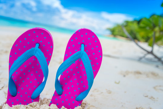 Pink beach flip flop on beautiful tropical island white sand beach summer holiday - Travel summer vacation concept.	